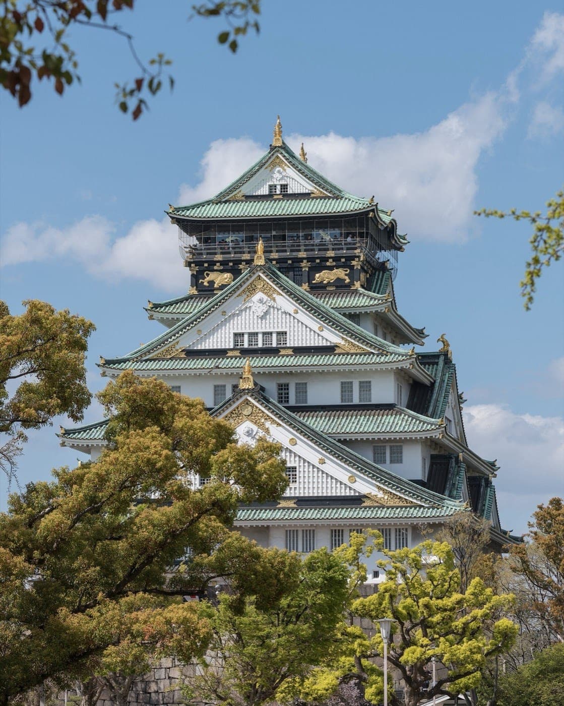 La torre del castillo de Osaka, blanca con techos verdes y detalles dorados